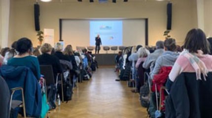 Die Bürgermeisterin von Walsrode und Mitarbeiterinnen und Mitarbeiter unterschiedlicher Einrichtungen vor einer Holztreppe.