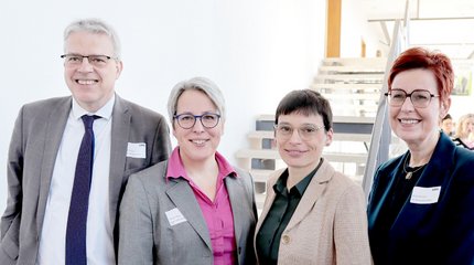 Die Bürgermeisterin von Walsrode und Mitarbeiterinnen und Mitarbeiter unterschiedlicher Einrichtungen vor einer Holztreppe.